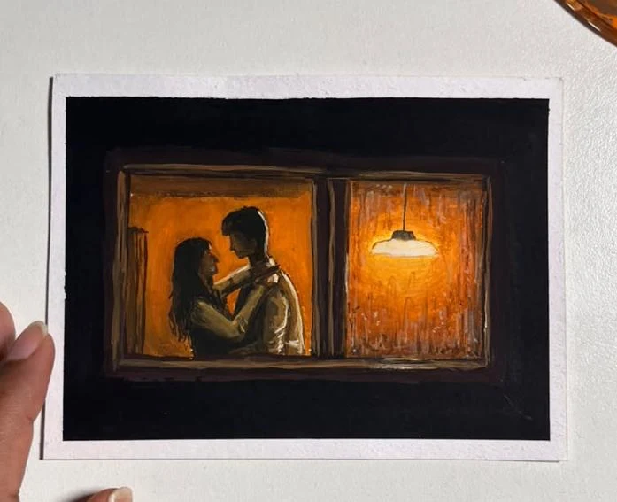 A couple shares a tender moment behind a warmly lit, rain-streaked window.