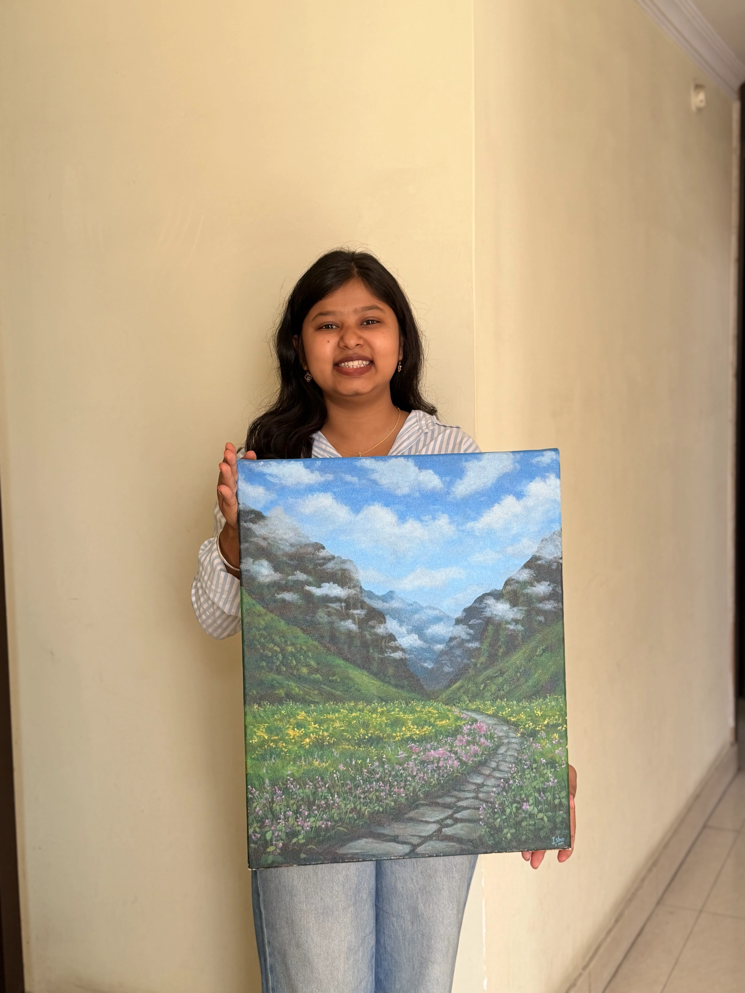 Isha holding a large mountain valley painting